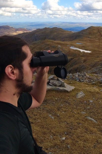 Young Male Looking Trough the Avian Evo Binoculars in the Wild